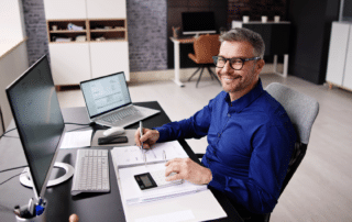 Happy man working at desk with financial documents