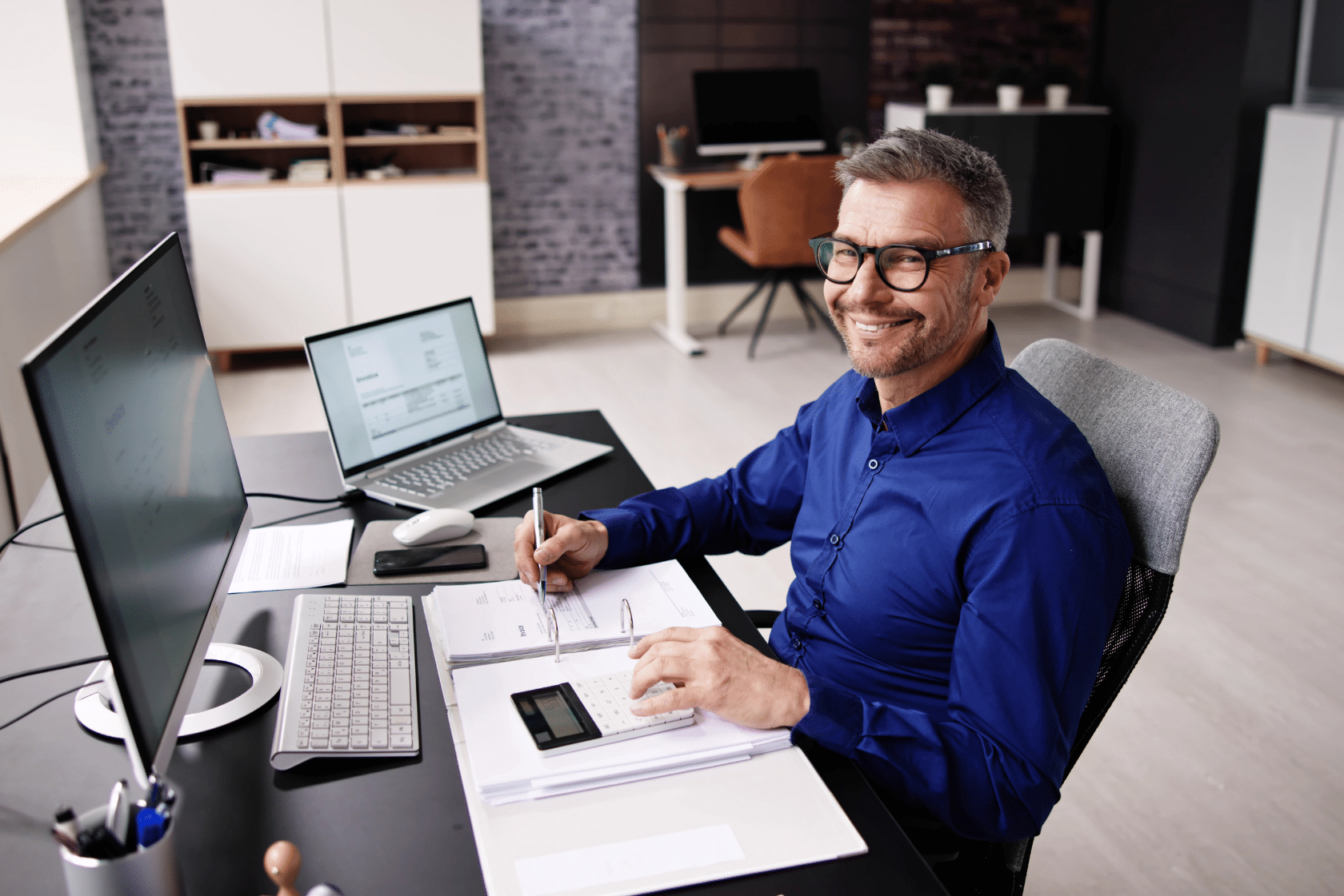 Happy man working at desk with financial documents